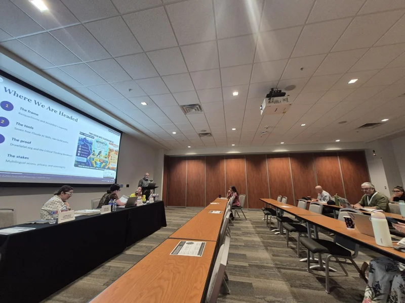 Wide view of the LACDH26 room, with participants seated around tables and a presenter at the front.